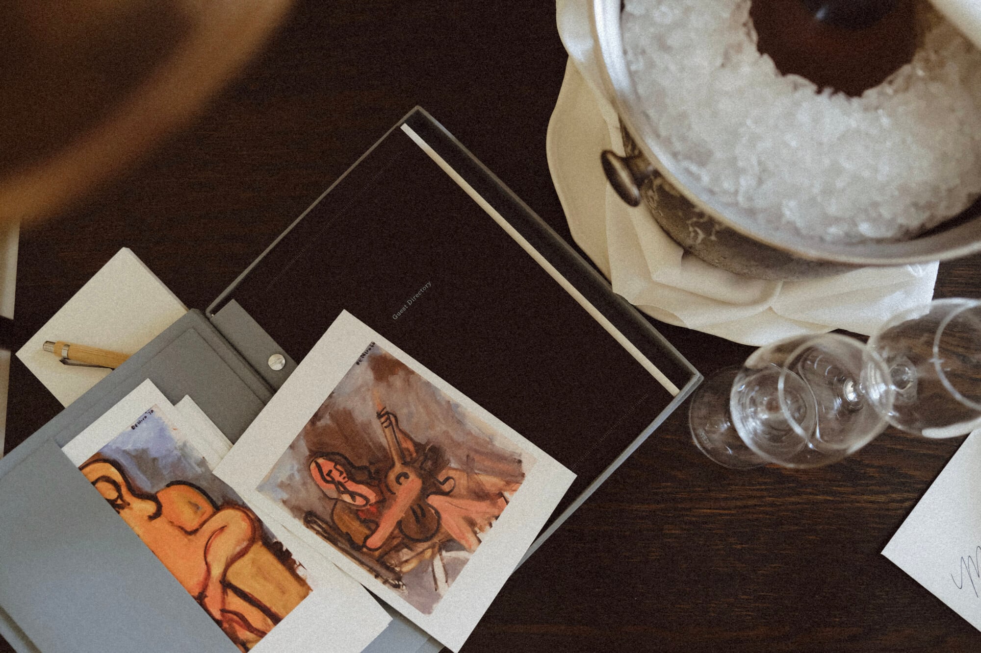 The Greenwich Hotel, New York, United States — Design sketches and watercolor studies spread across dark wood desk with glass vessels and cream-colored notebook.
