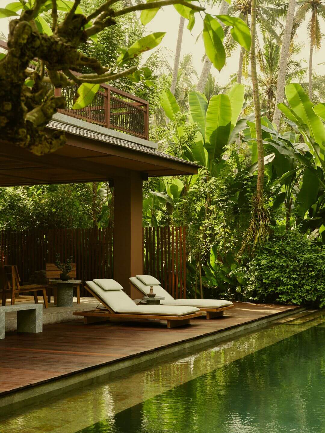 Lost Lindenberg, Asia — Wooden deck with loungers overlooking reflecting pool, tropical palms and lush green vegetation under modern pavilion with brown timber structure.