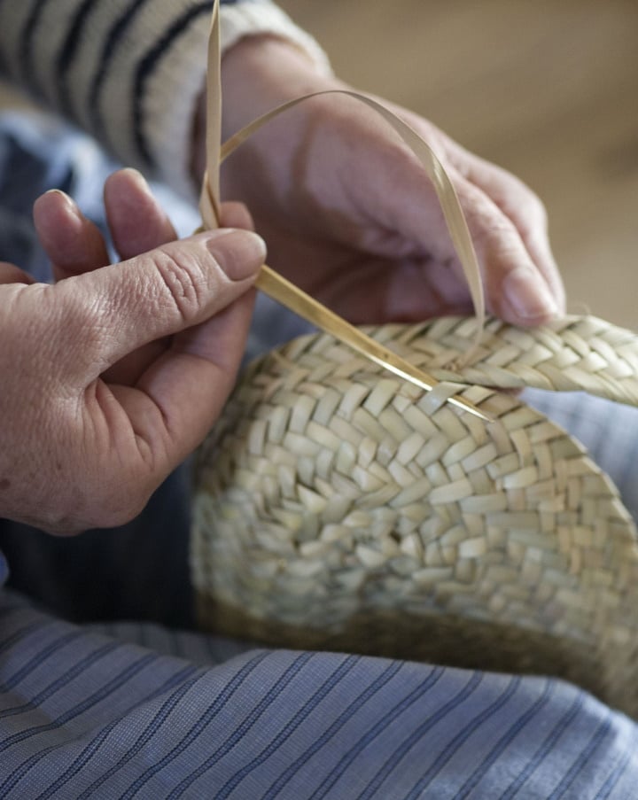 Local Workshops, Balearic Islands, Spain — Hands weaving natural straw material with fine technique, detail of traditional craftwork and artisanal texture.
