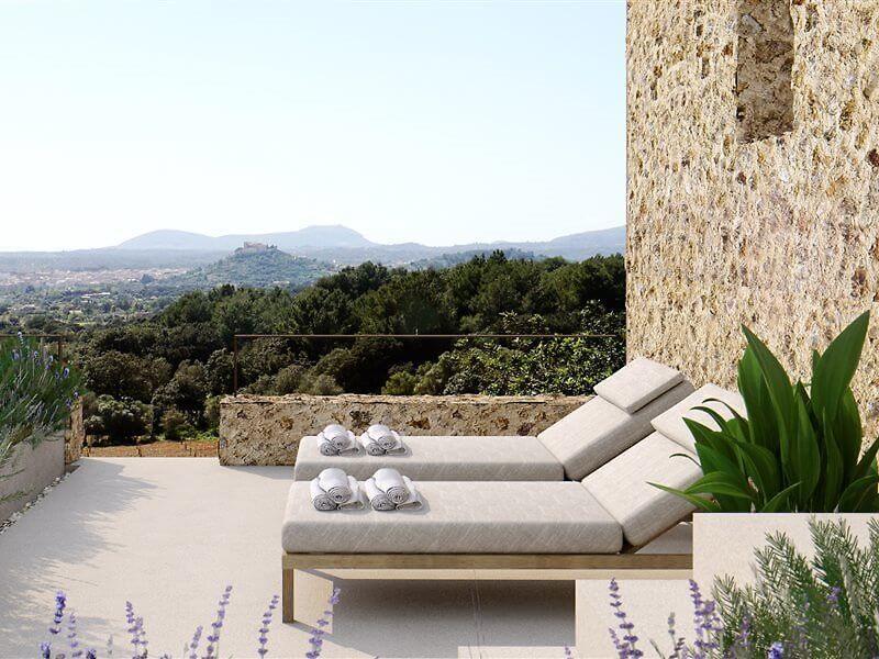 Es Racó d'Artà, Balearic Islands, Spain — Limestone terrace with dual loungers, lavender, mountain views, and Mediterranean landscape at sunset.