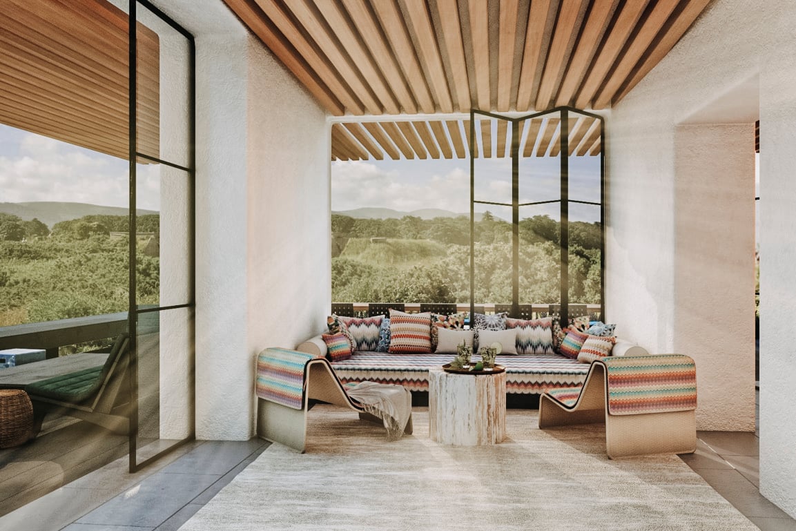 Casa Buscastell, Balearic Islands, Spain — Modern terrace with wooden slatted ceiling, panoramic landscape views, built-in seating with colorful textiles, and minimalist stone table.