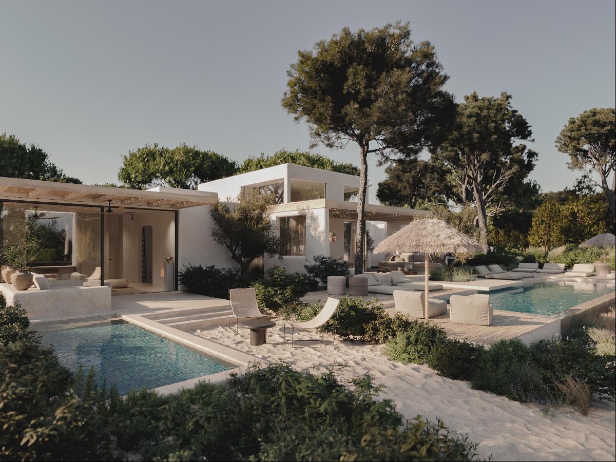 NUMA Comporta, Portugal — Modern white villa with curved architecture, thatched-roof pavilion, multiple pools, and mature pine trees in serene coastal landscape.