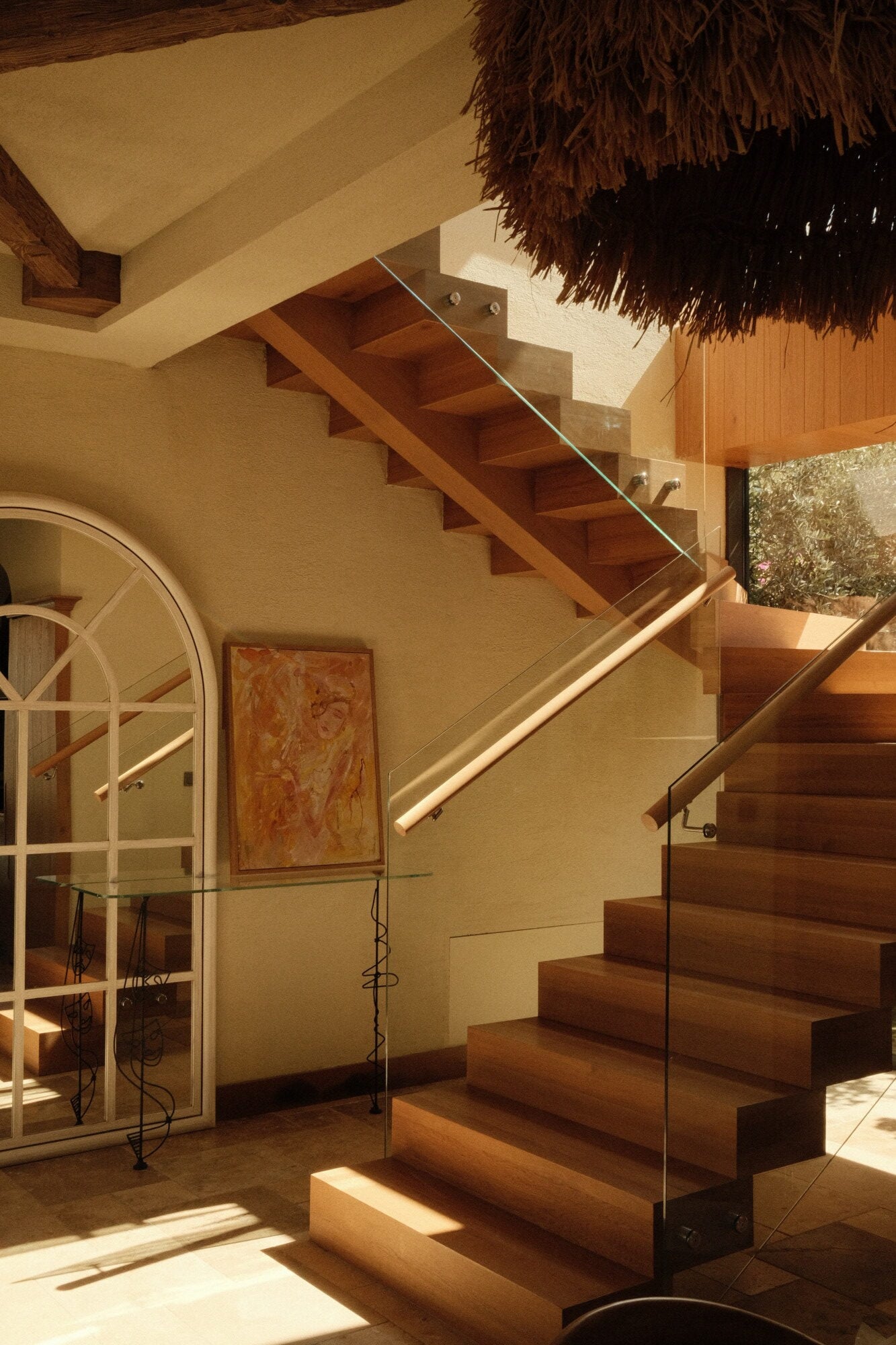 Villa Thalia by Muses Kalkan, Kalkan, Turkey — wooden staircase with glass railing, cream walls, natural light, thatched ceiling detail, Mediterranean minimalist design.