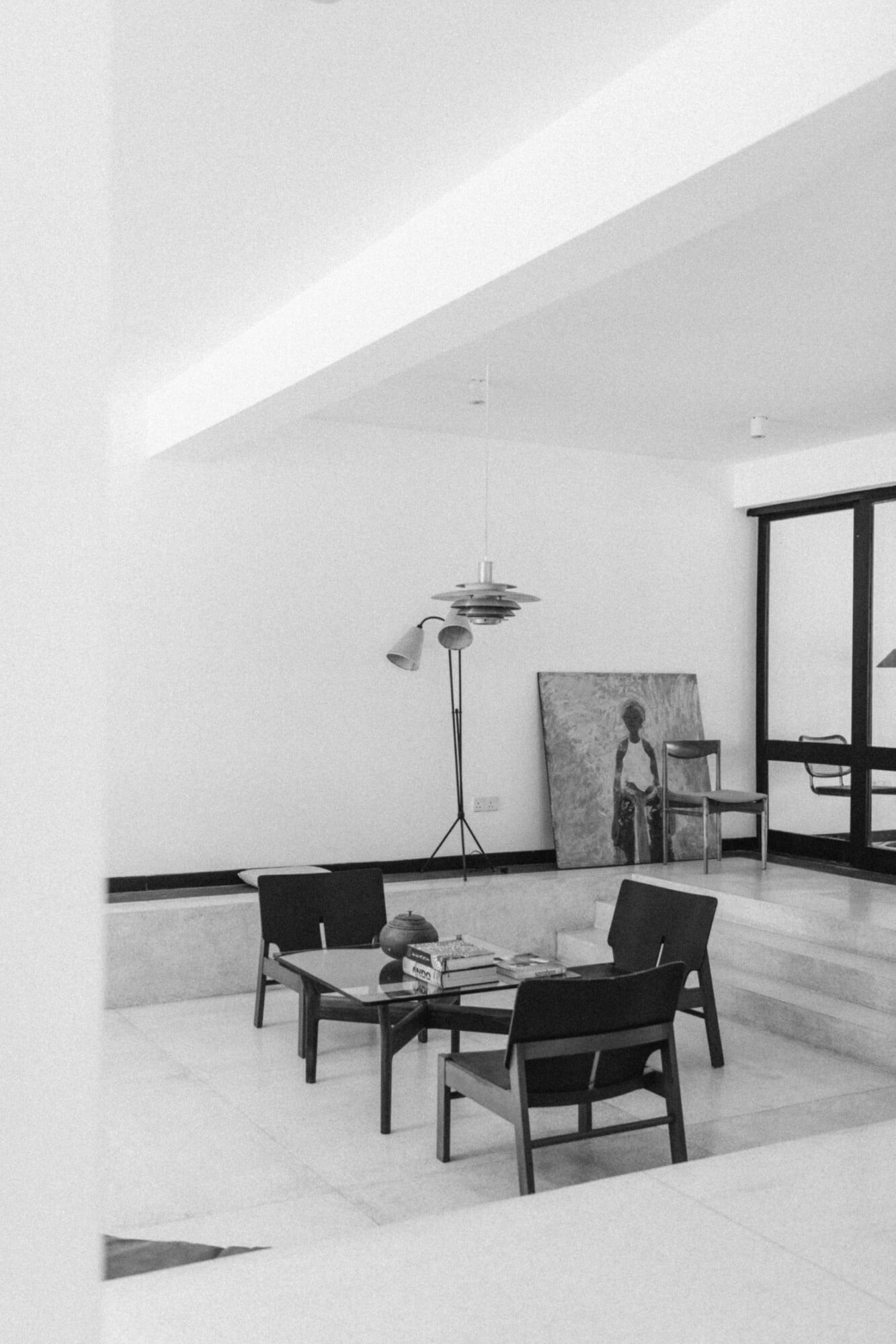 Kurulu Bay, Asia — Minimalist lounge with sculptural pendant light, black chairs, marble flooring, and floor-to-ceiling windows in clean modernist interior.