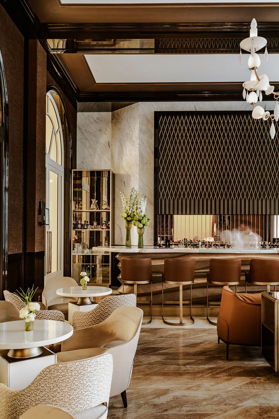 Carlton Cannes, Côte d'Azur, France — Luxury spa lounge with marble walls, cognac leather chairs, brass accents, geometric patterned panels, and skylit coffered ceiling.