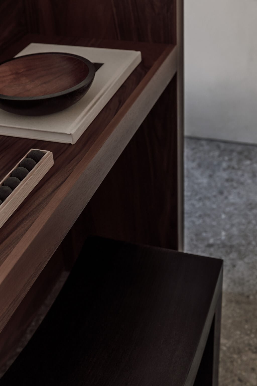 Casa Cook Samos, Greece — Dark wood shelf with ceramic bowl, black stones, and minimalist decor overlooking grey stone terrace