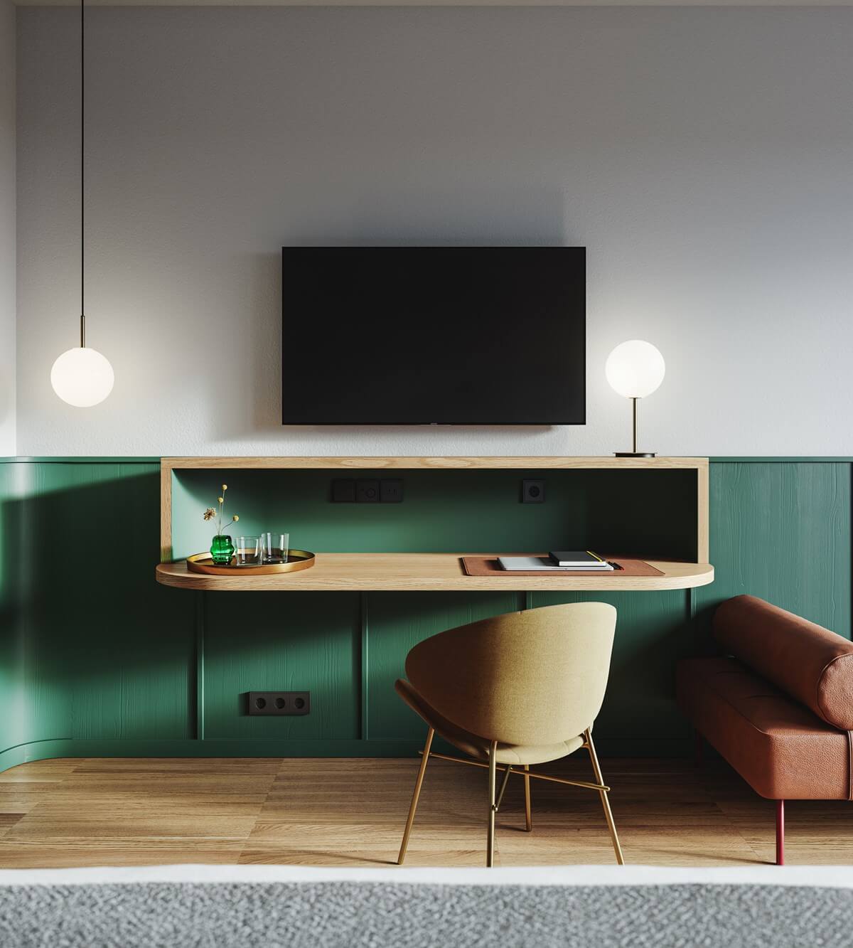 The Cōmodo — Cōmodo, Europe — Modern hotel workspace with curved green paneling, wooden desk, cream chair, pendant lighting, and wall-mounted TV above minimalist cabinetry.