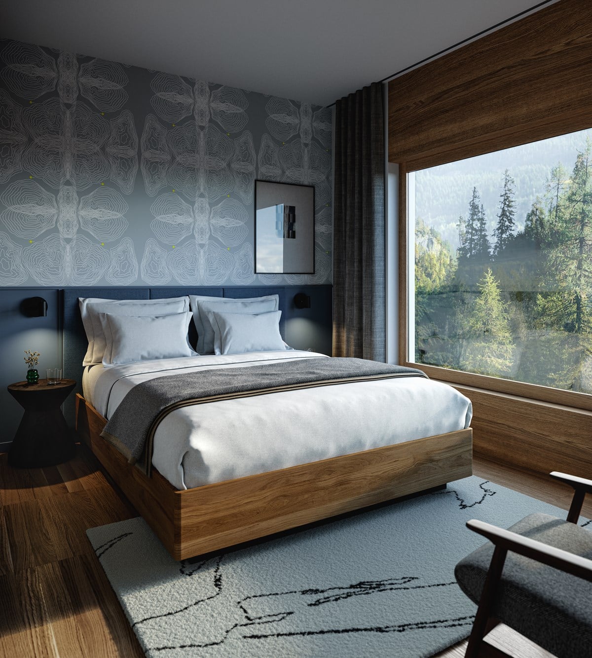 The Cōmodo — Cōmodo, Europe — Modern bedroom with walnut bed frame, blue upholstered headboard, forest views through floor-to-ceiling windows, patterned gray wallpaper, warm wood flooring, and minimalist furnishings.