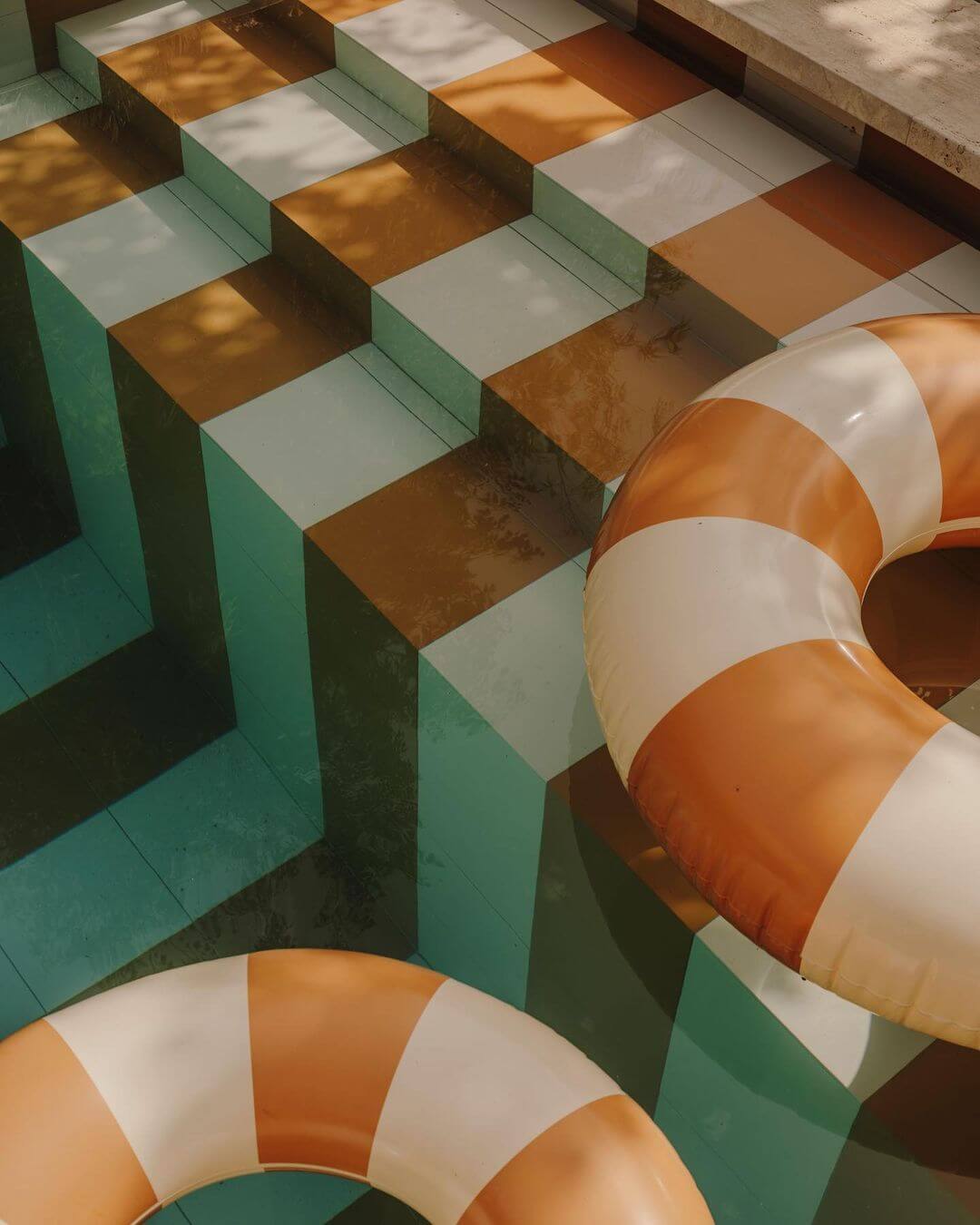 Santa Teresa 34, Balearic Islands, Spain — Striped orange and white buoys stacked against turquoise geometric architectural elements under Mediterranean sunlight.