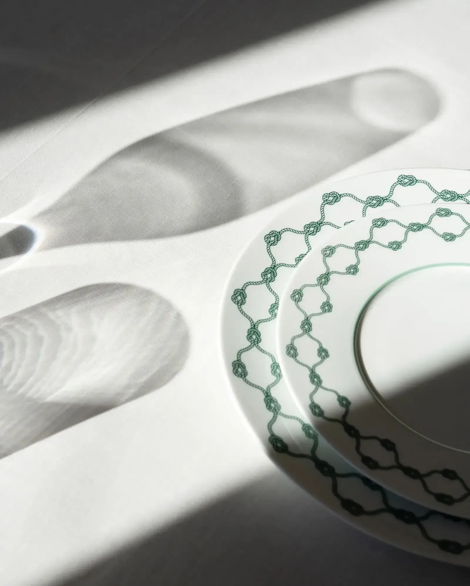 Splendido Mare, Europe — White ceramic tableware with green embroidered linen napkin, minimalist luxury dining detail with natural light and shadow.