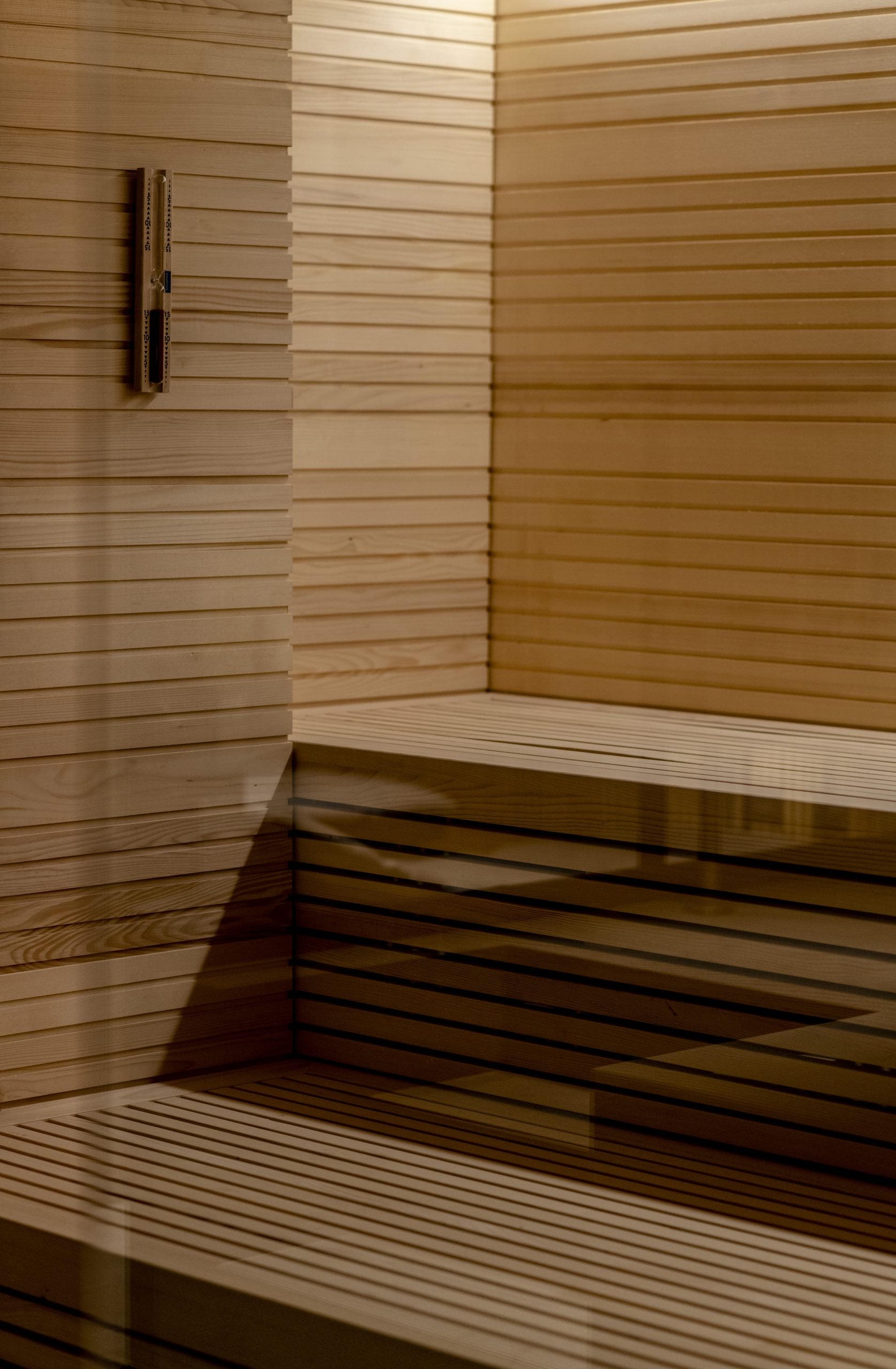 Lelòse Spa, Europe — Wooden sauna interior with horizontal shiplap walls, tiered bench seating, and warm natural light casting geometric shadows across the spa relaxation space.