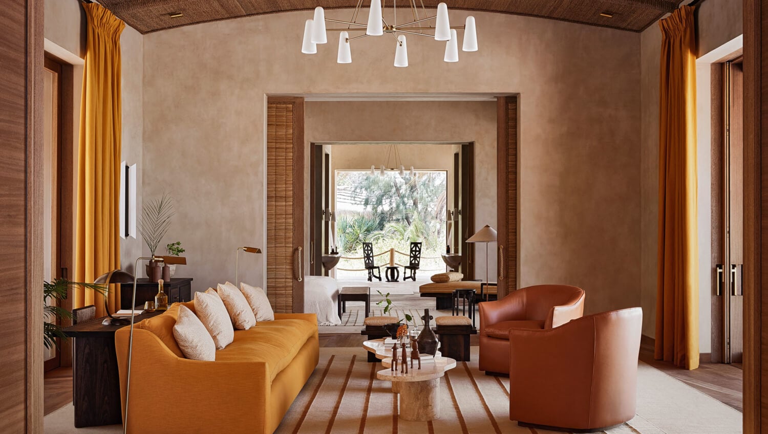 Kisawa Sanctuary, Africa — Ochre living room with terrazzo floors, leather seating, and open doors to tropical garden views.