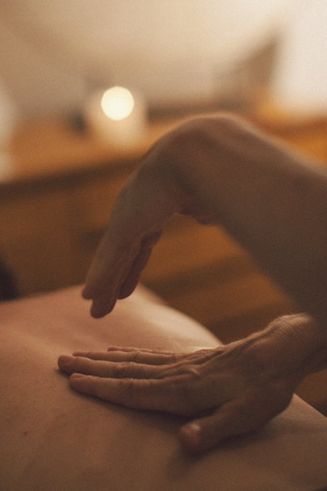 The Spa, Asia — Hands performing massage treatment in warm candlelit spa setting, luxury wellness therapy