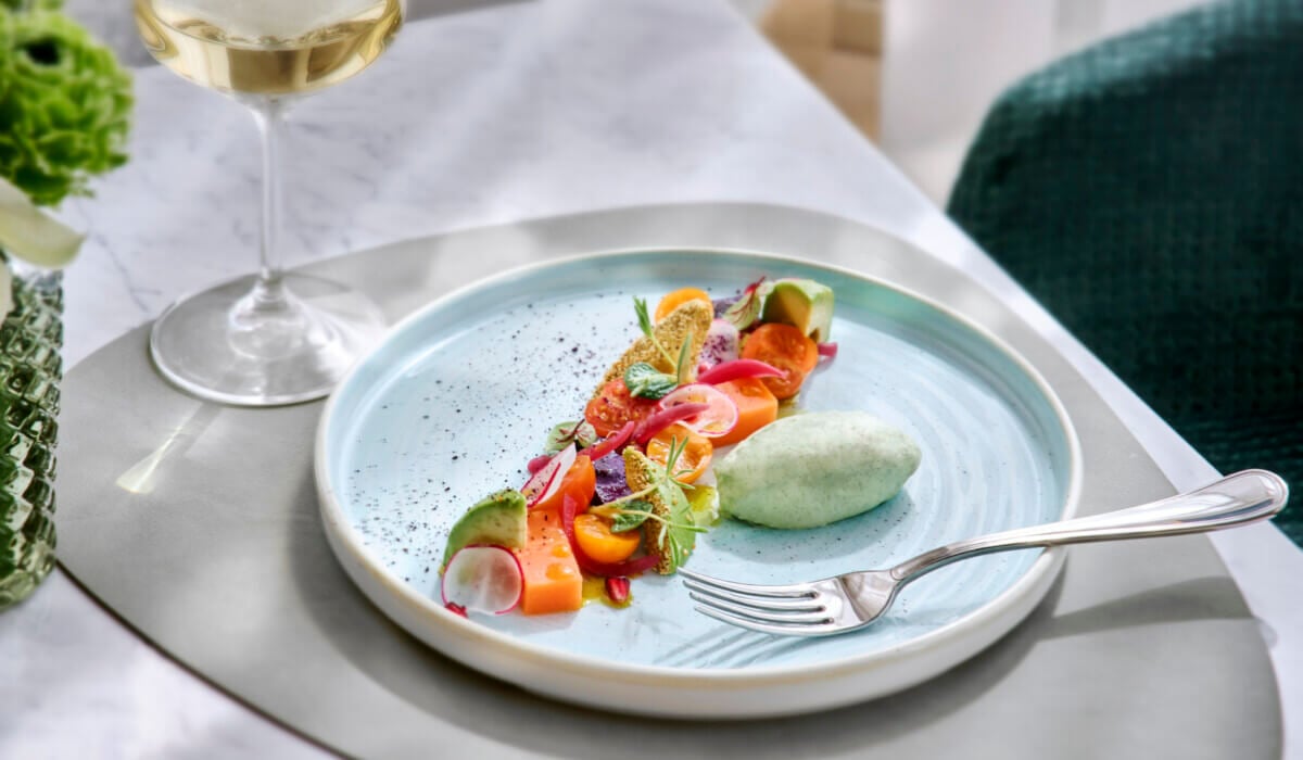 Riviera Restaurant, Europe — Elegantly plated salmon with microgreens and edible flowers, paired with pale wine in minimalist fine dining ambiance.