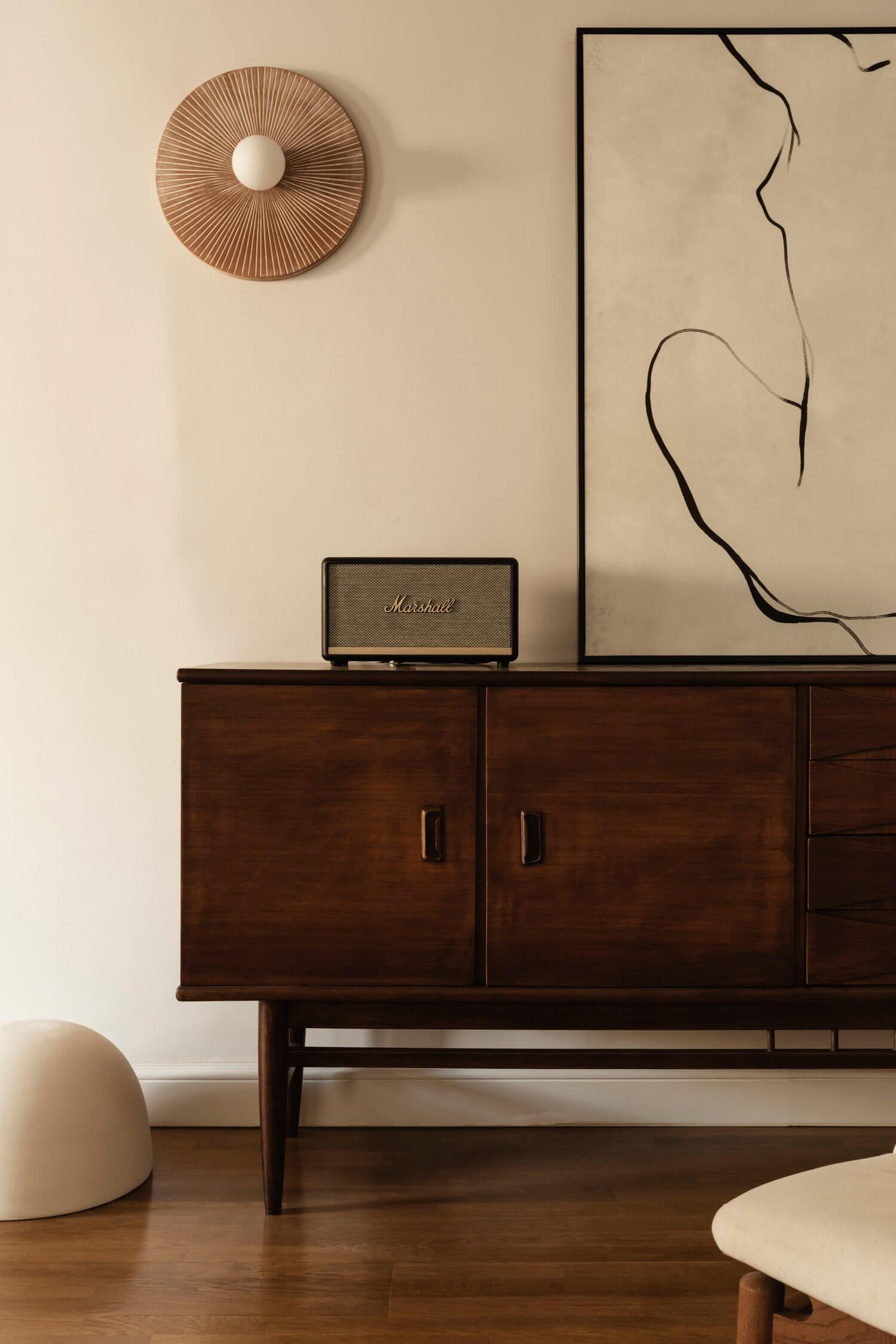 Casa Somos Suenos, Europe — Mid-century sideboard with Marshall speaker and sculptural wall art in minimalist interior with natural light.