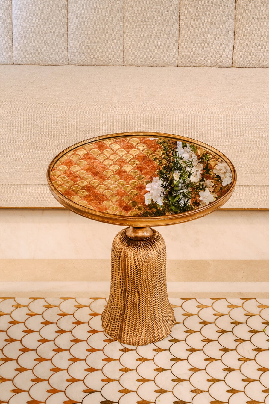 Carlton Cannes, Cannes, France — Gilt pedestal table with oval mirror reflecting orange damask pattern and white flowers against beige paneled walls.