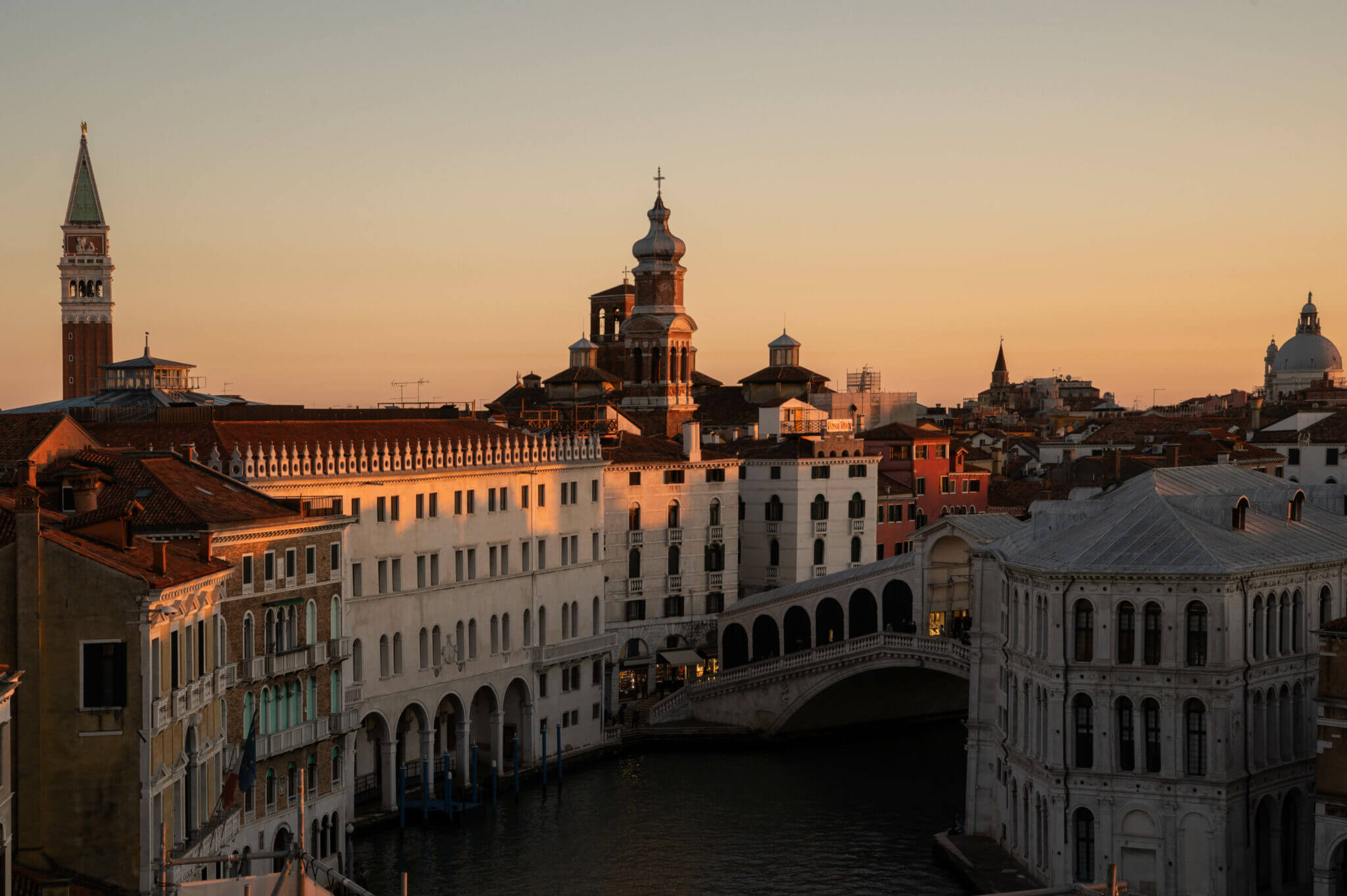The Venice Venice Hotel, Venice, Italy — Rialto Bridge and palazzo facades at golden hour, Venetian Renaissance architecture reflected in Grand Canal waters.